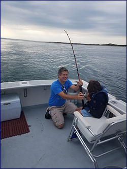 A young angler doing battle with a nice fish with Bluefin Charters